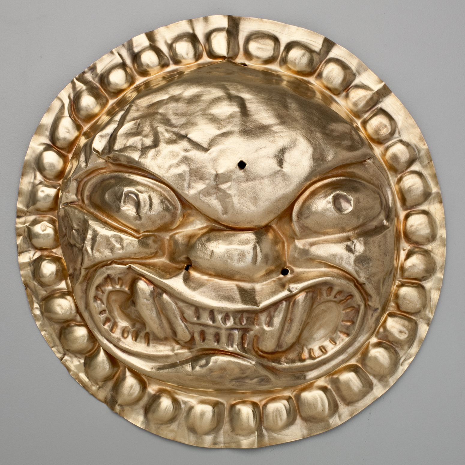 A gold circle with a snarling feline face