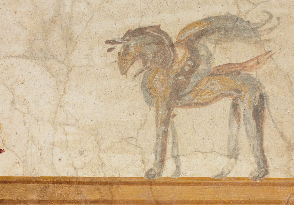 Fragment of a Roman wall fresco with a winged horse, red spear, and gold tabletop shown