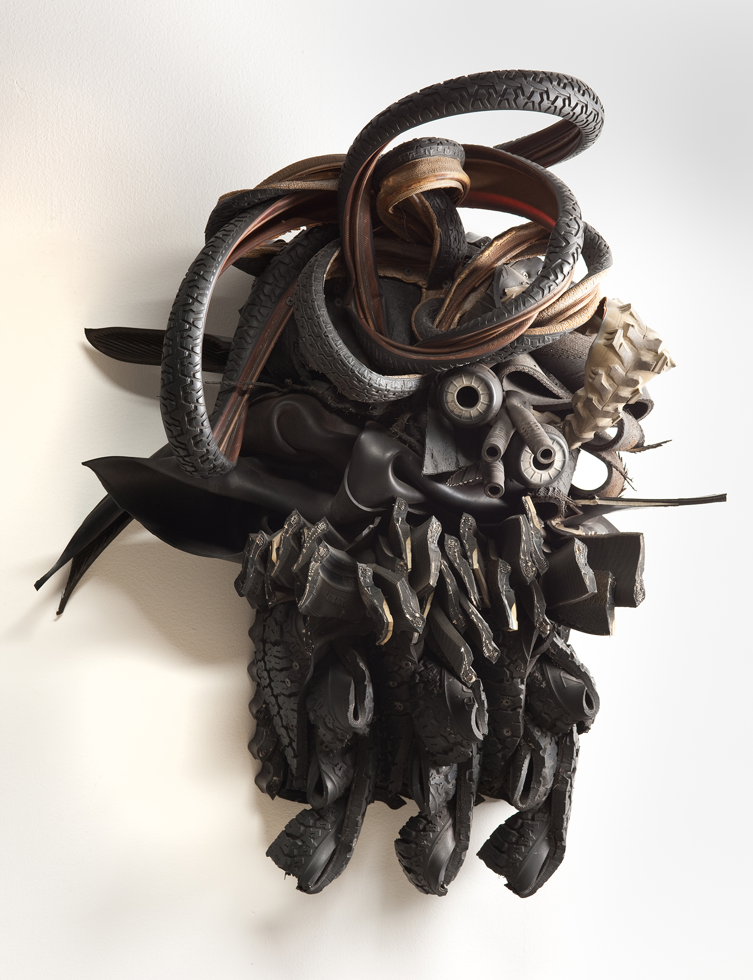 A hanging sculpture made of different sizes and shapes of tires and other rubber objects