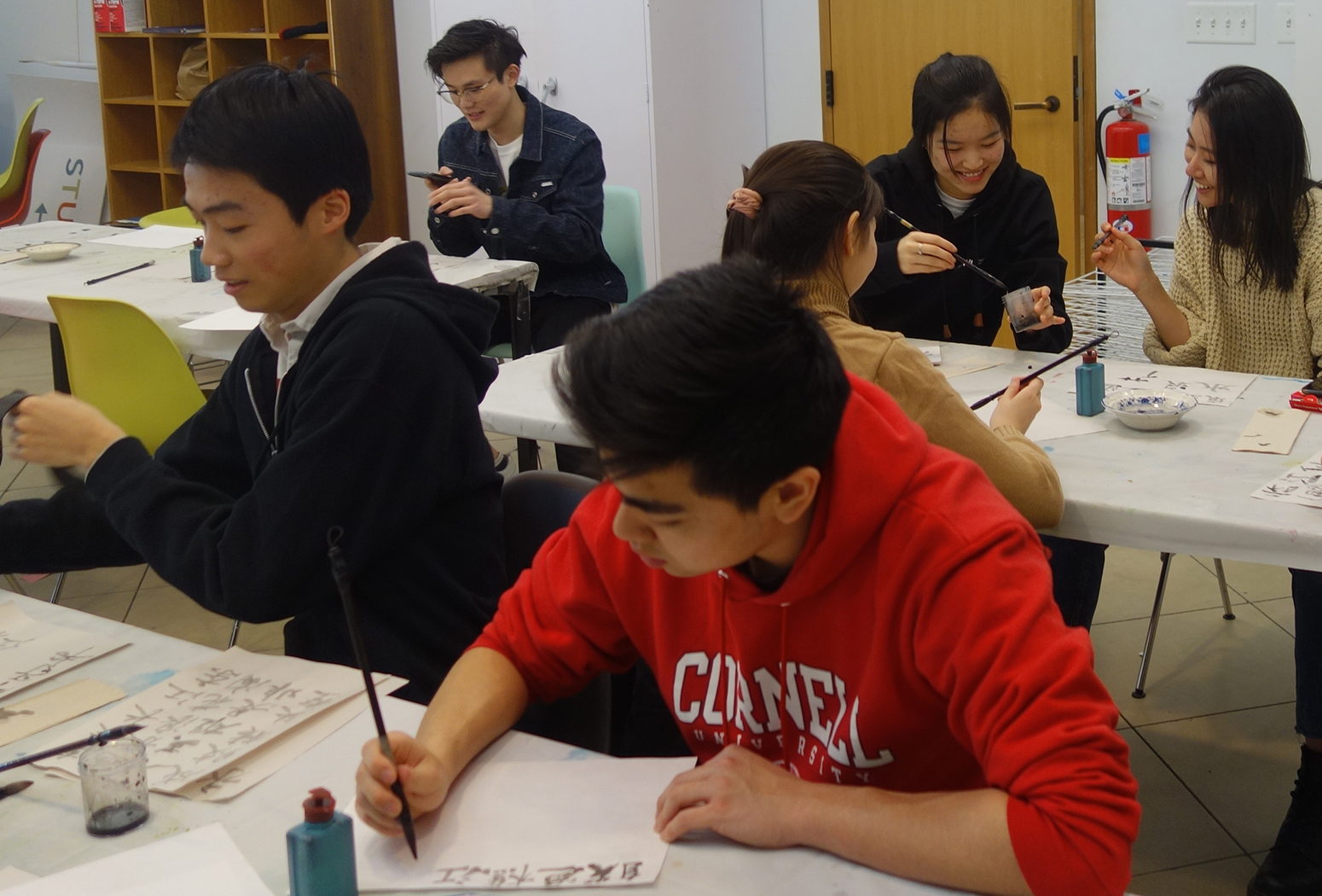 A group of college students learn Chinese calligraphy in an art studio workshop