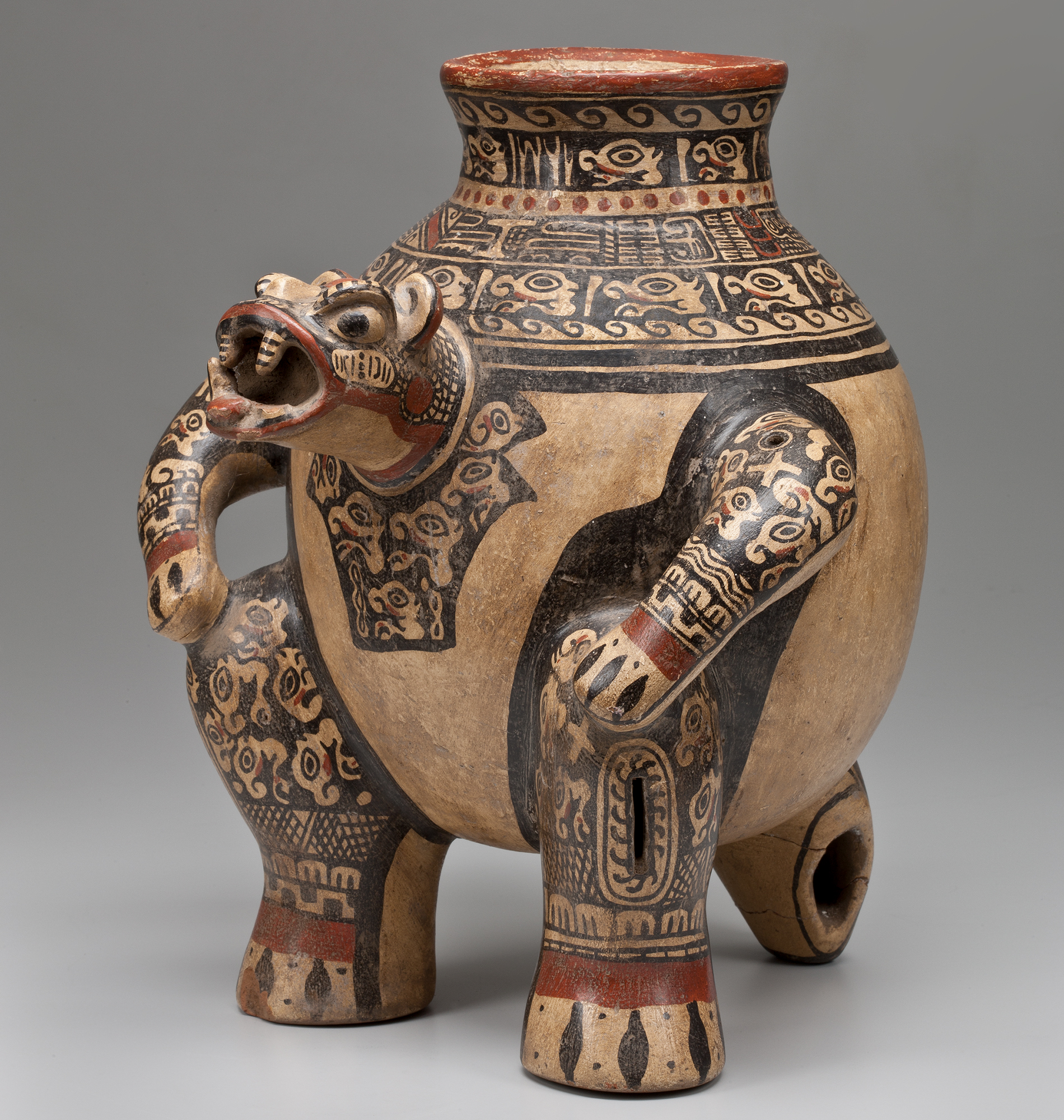 A painted jug with an animal head spout and two arms, supported by two feet and a tail