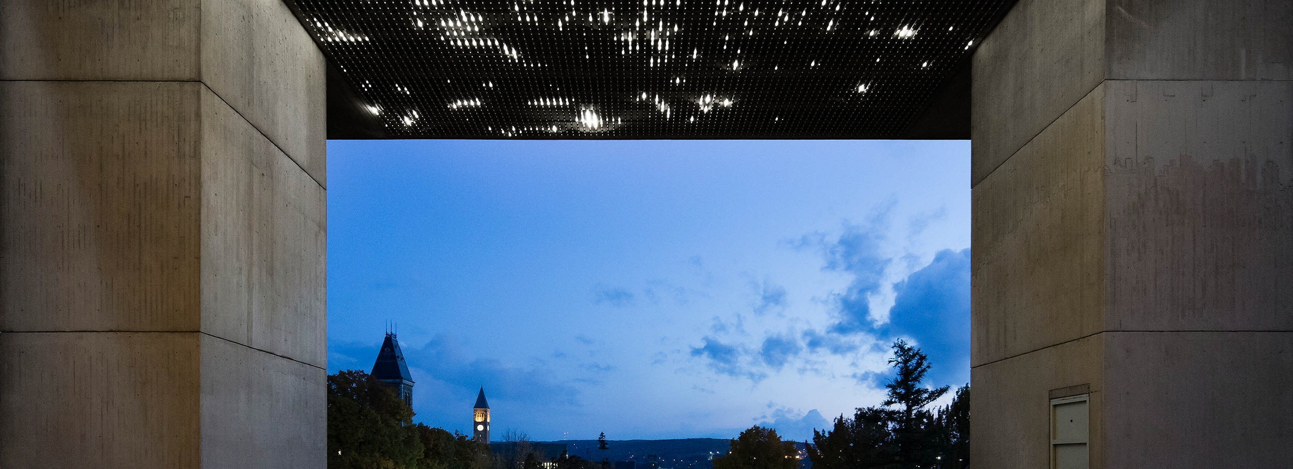 The ceiling of an outdoor courtyard is covered with thousands of white lights at twilight