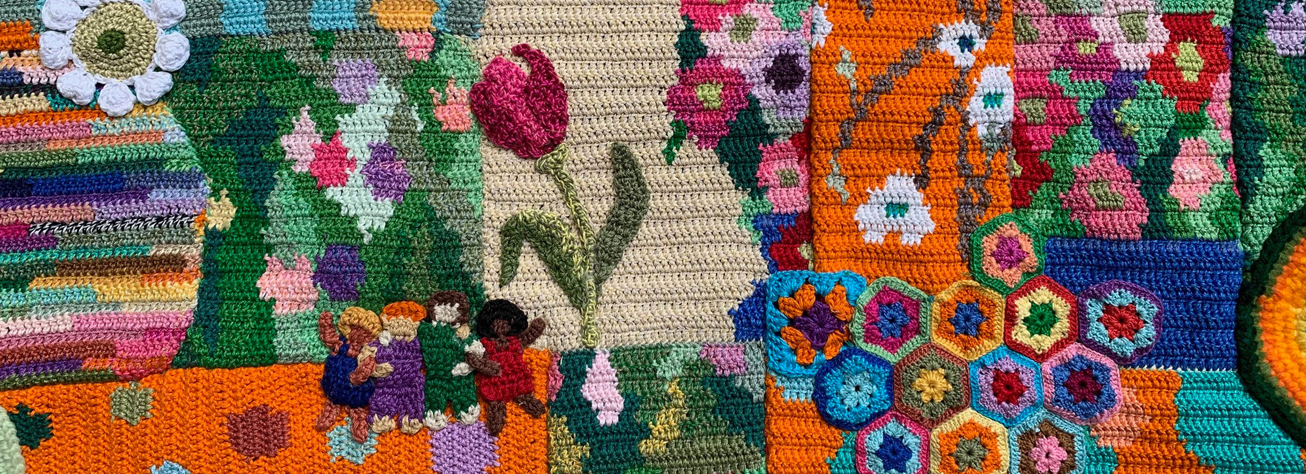 A colorful patchwork of crocheted flowers, people, and patterns