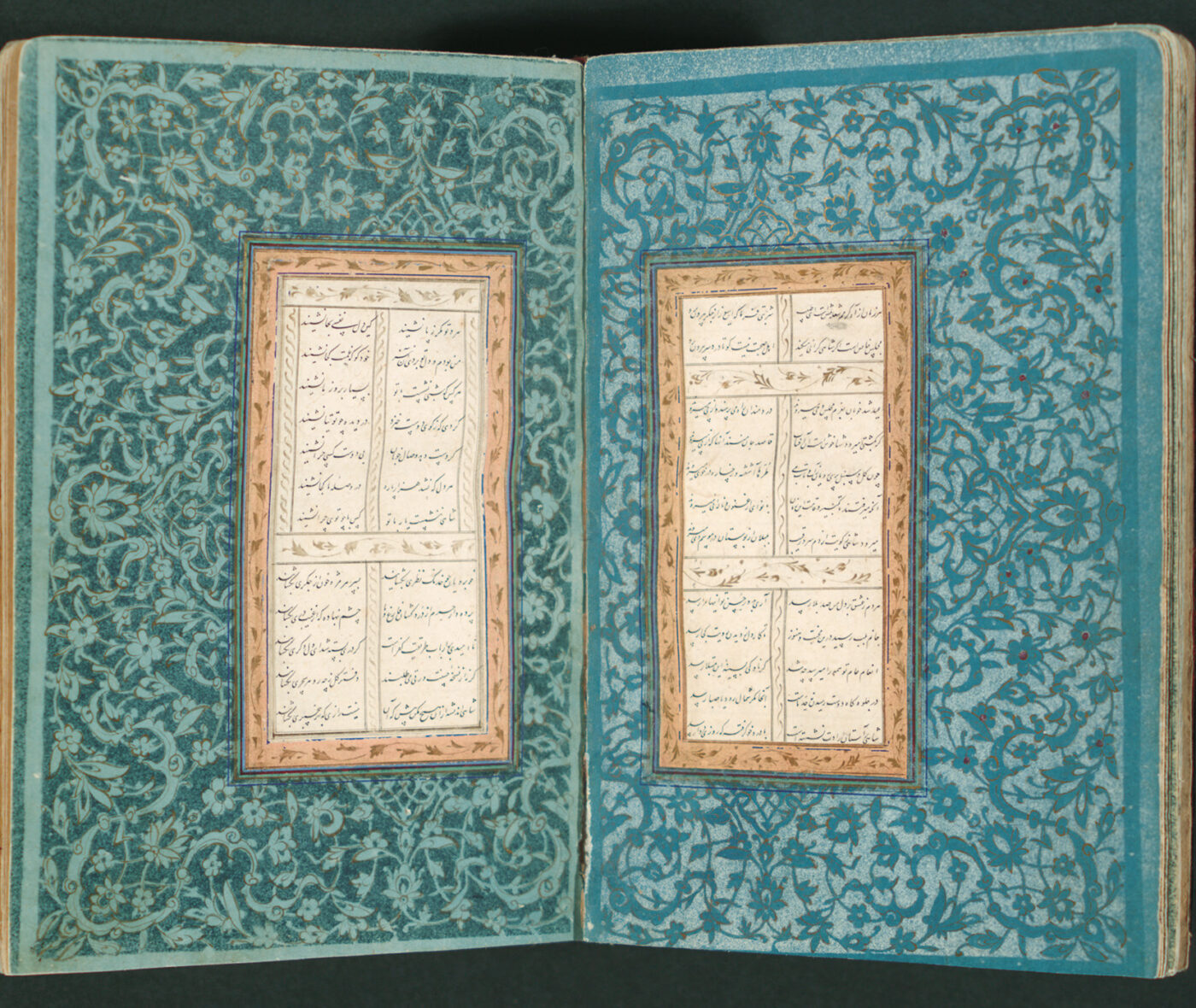 An open bound manuscript with Persian calligraphy and a floral design in blues and greens