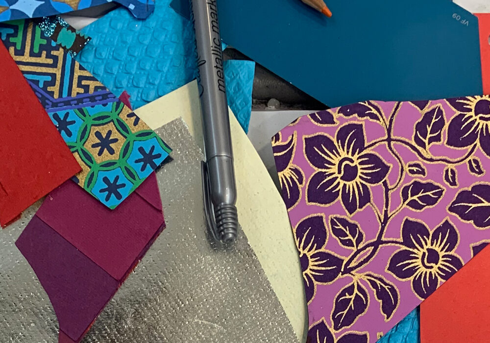 A collage of colorful patterned papers, pens, and scissors