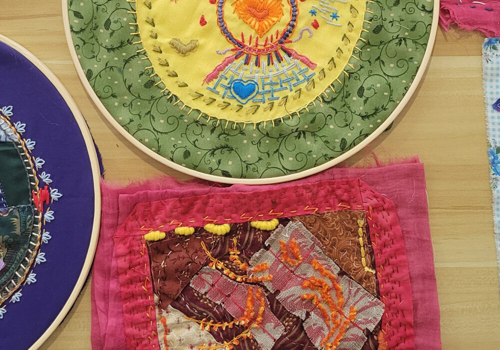 Colorful works of embroidery in and out of their hoops