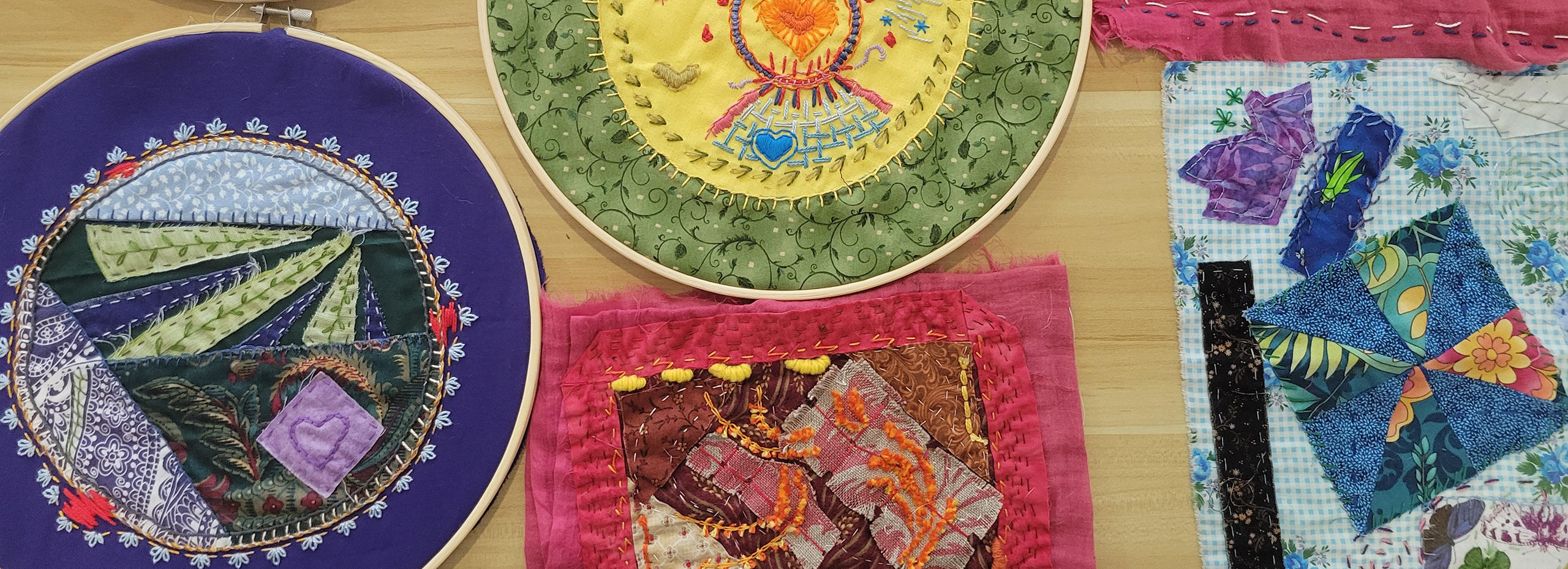 Colorful works of embroidery in and out of their hoops