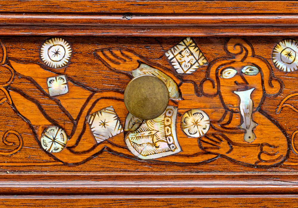 A carved wood drawer from the 18th century with decorative mother-of-pearl and bronze details