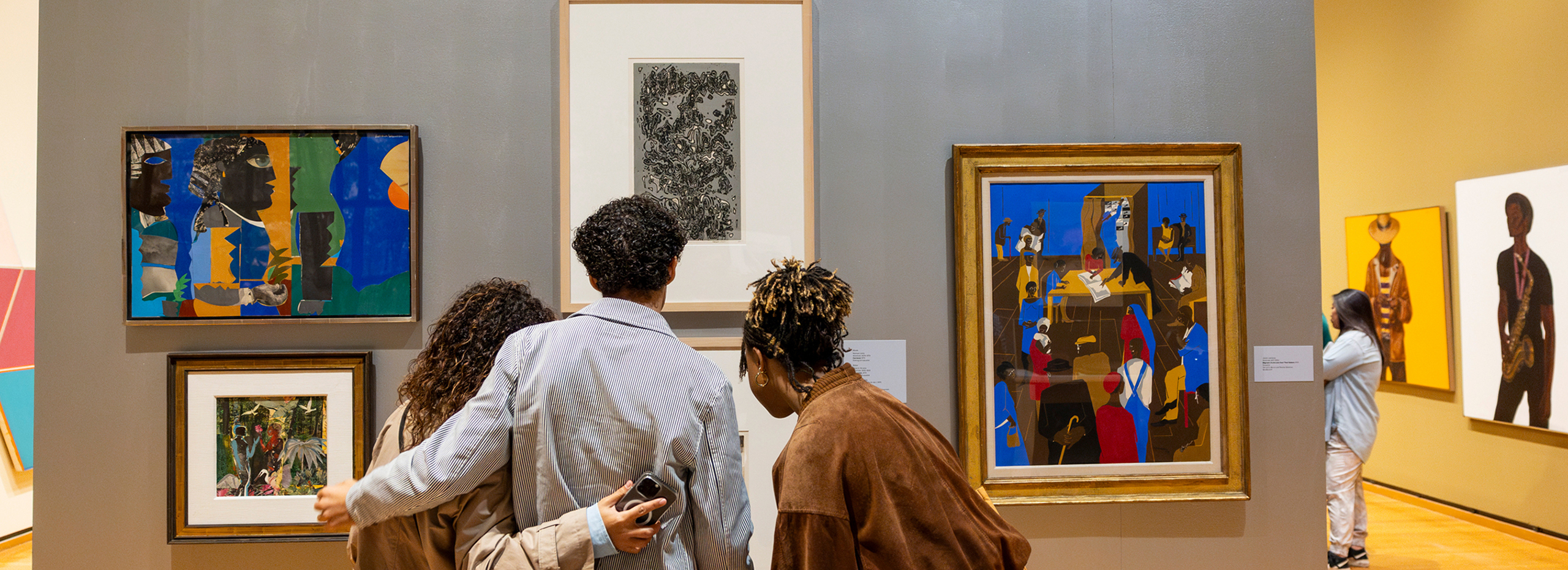 People look at artworks in a colorful museum gallery