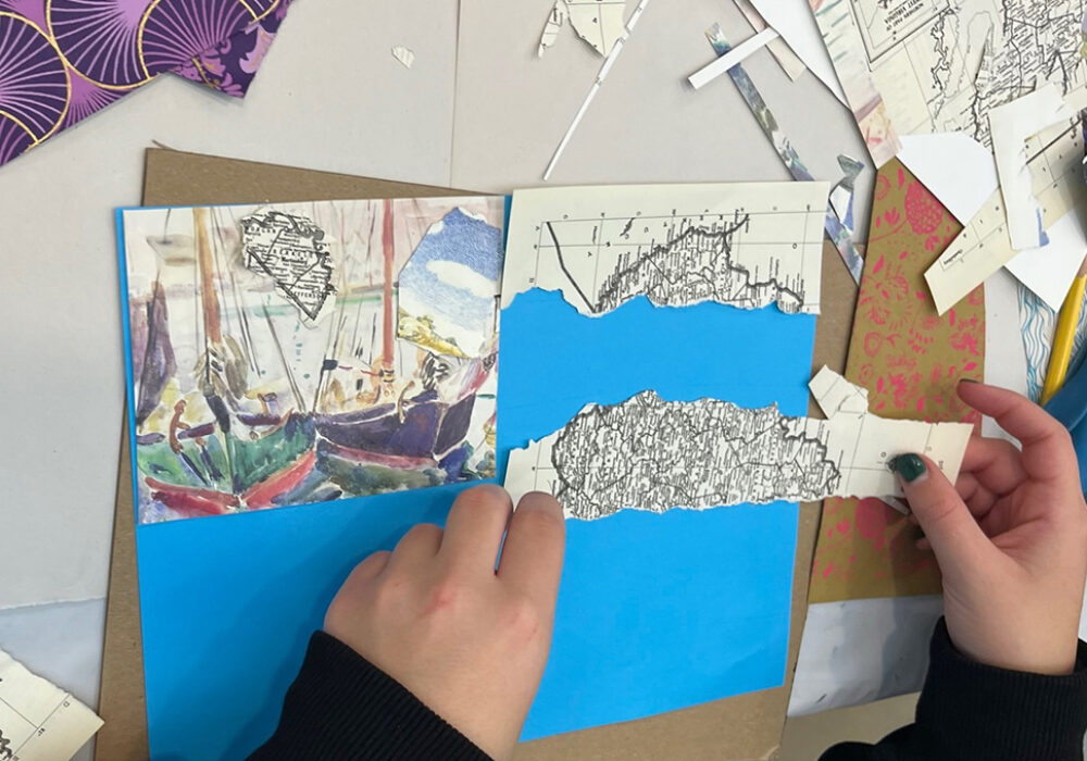 Hands at work on a collage project with maps