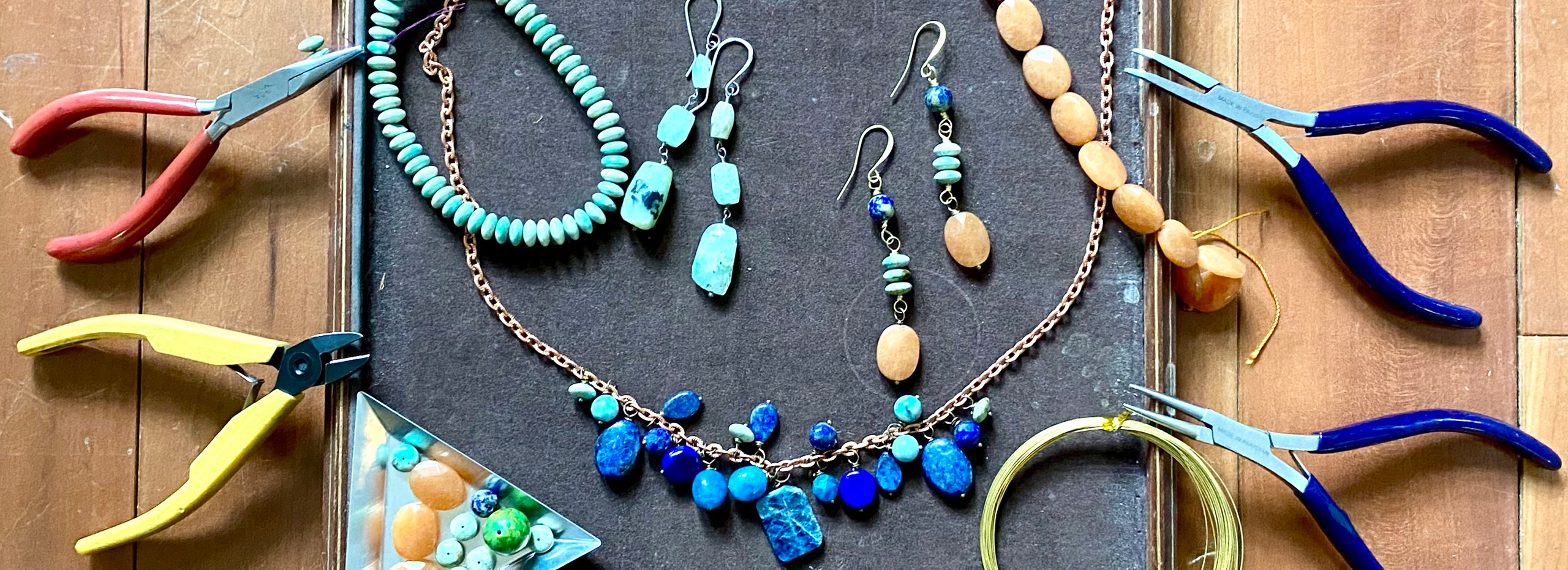 A box of beaded jewelry and wire cutting tools