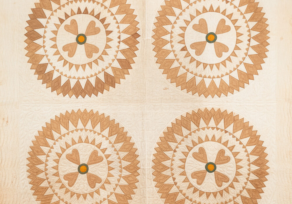 American Quadrant quilt with a sunburst-type pattern in cream and golden tones