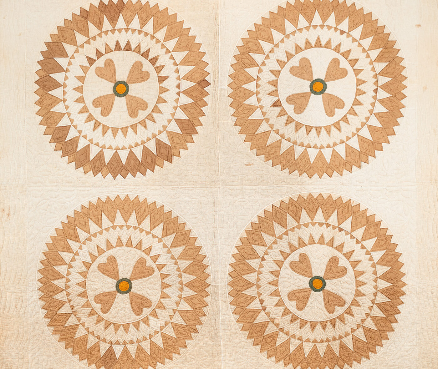 American Quadrant quilt with a sunburst-type pattern in cream and golden tones
