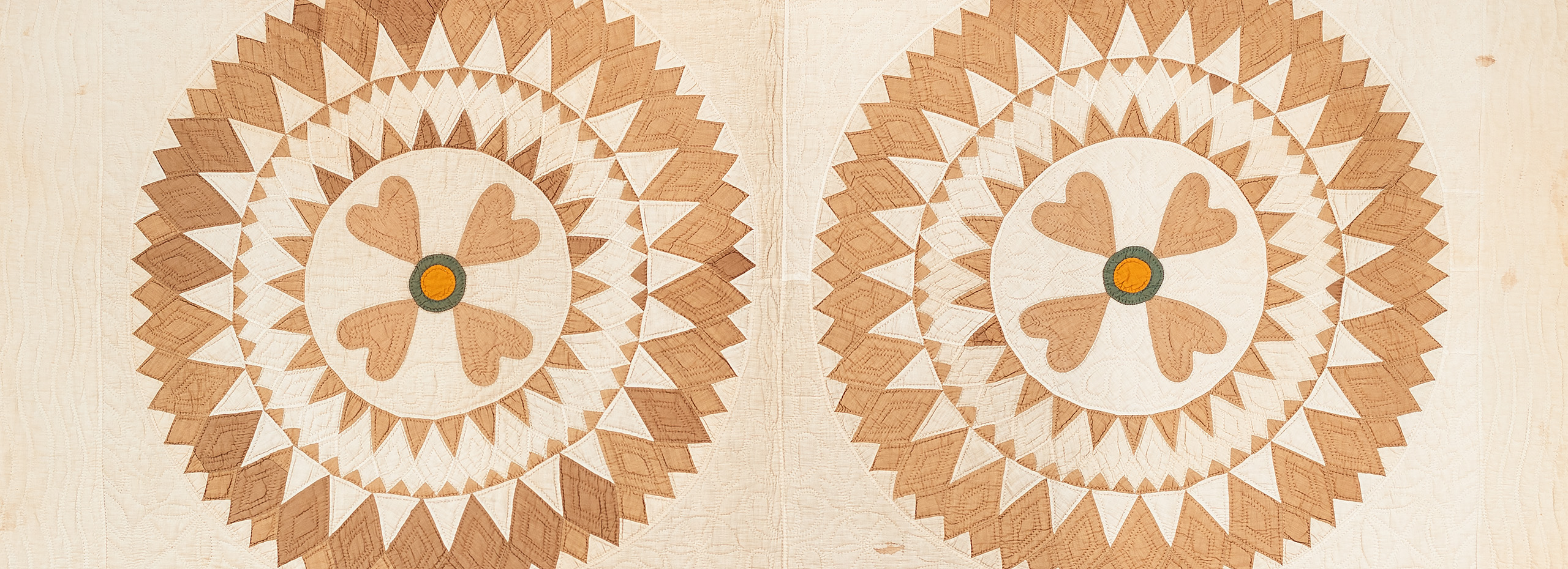 Portion of an American Quadrant quilt with a sunburst-type pattern in cream and golden tones