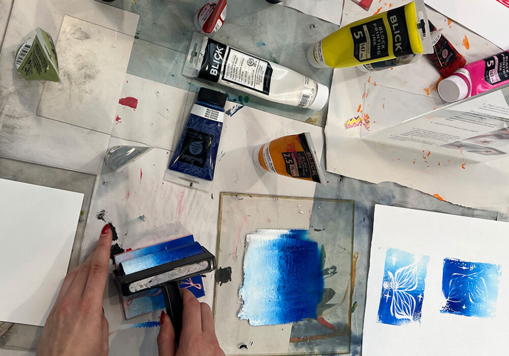 Tubes of red and black paint on a messy studio table