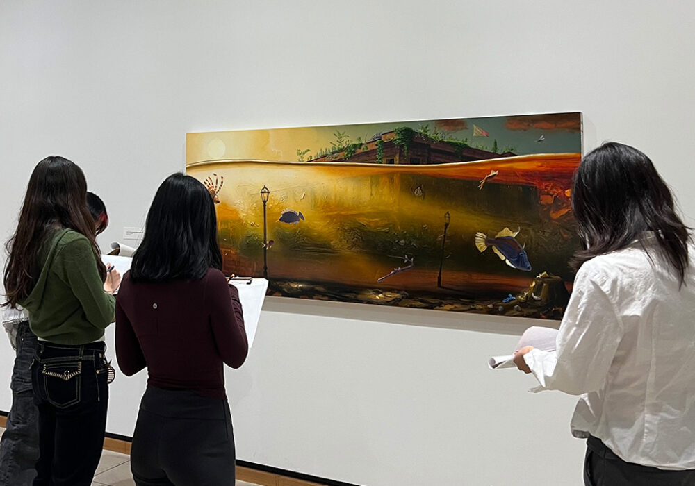 Students take notes looking at a large horizontal painting in a gallery