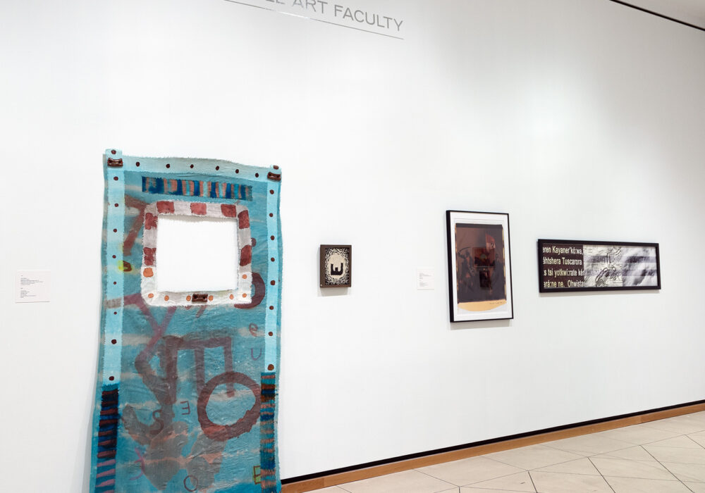 Four artworks hang on a white wall