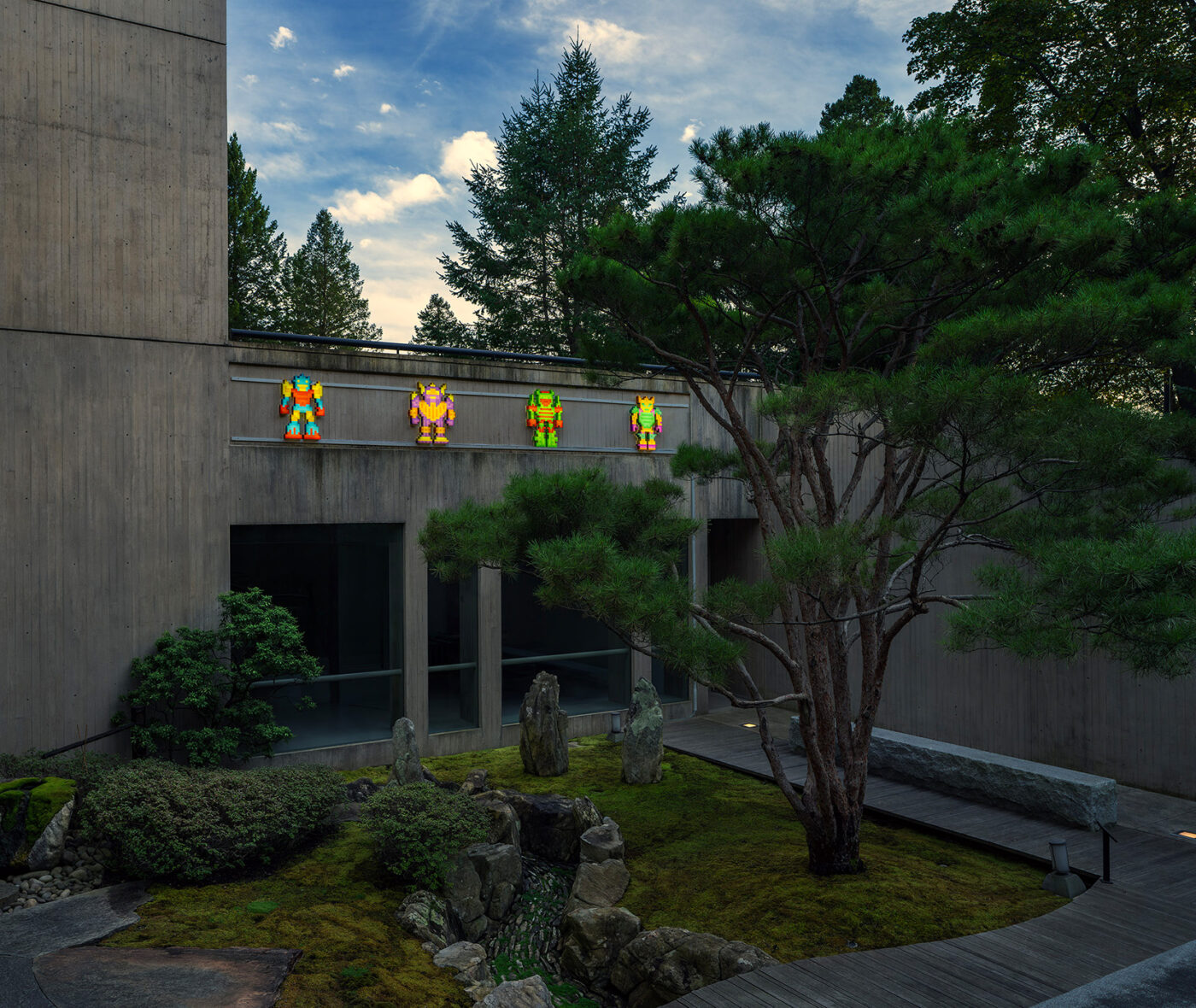 Four colorful pixelated figures are placed above a Japanese garden with a tall tree