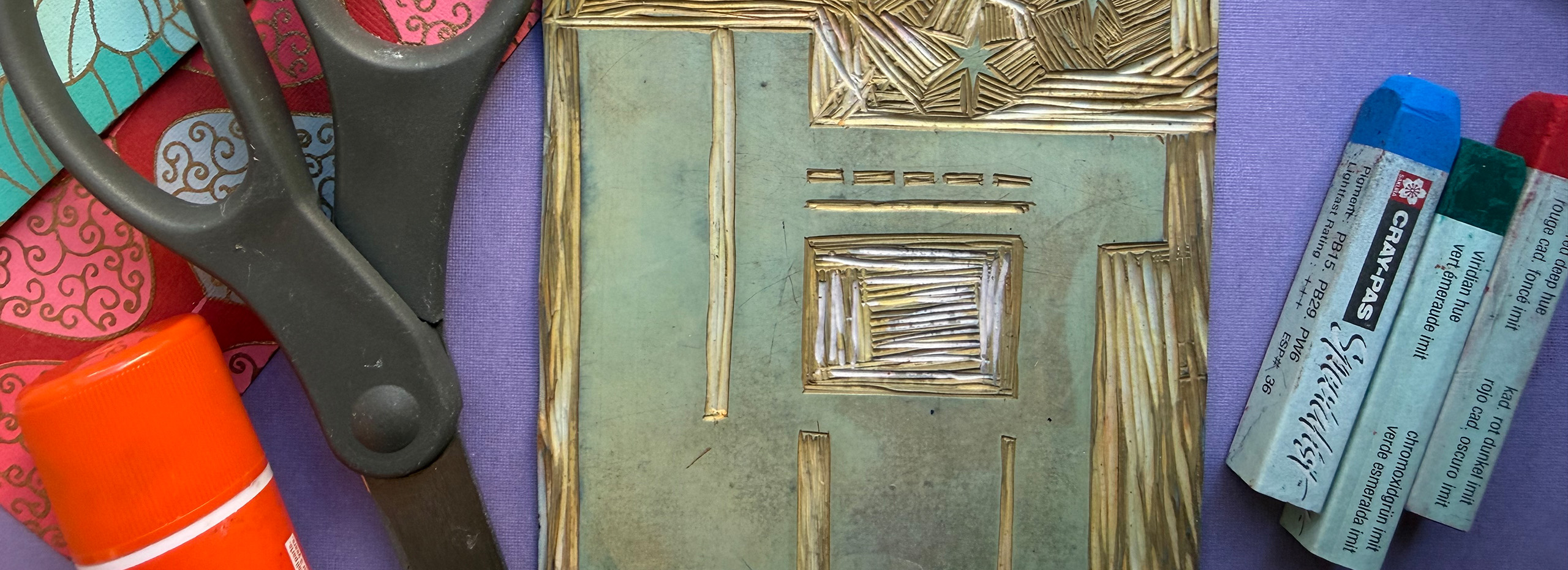 Colorful artmaking materials are displayed on a table