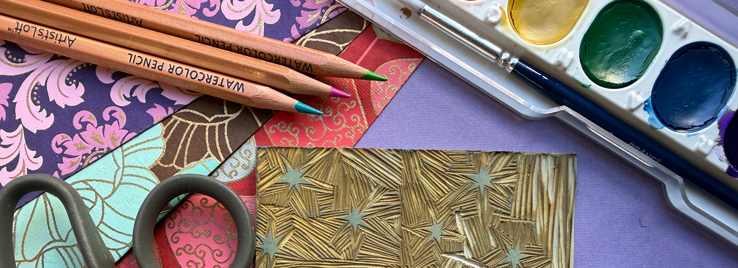 Colorful artmaking materials are displayed on a table
